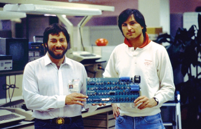 two men holding Apple product from early company days